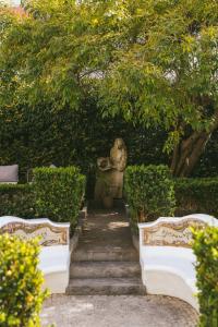 a stone stairway with a statue in a garden at Pergola Boutique Hotel in Cascais