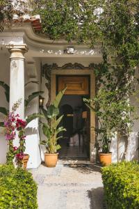 uma entrada para uma casa com vasos de plantas em Pergola Boutique Hotel em Cascais