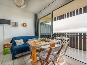 jadalnia ze stołem i krzesłami oraz balkonem w obiekcie Studio Les Océanides-18 by Interhome w mieście Lacanau-Océan
