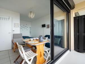 jadalnia z drewnianym stołem i krzesłami w obiekcie Studio Les Océanides-18 by Interhome w mieście Lacanau-Océan