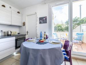 une cuisine avec une table et un chiffon de table. dans l'établissement Apartment Les Mirandas II by Interhome, à Saint-Cyprien