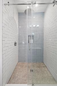 a shower with a glass door in a bathroom at Modern & Comfy ~ 5* Location~GameRoom~Backyard in Philadelphia