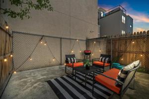 a patio with a table and chairs and lights at Modern & Comfy ~ 5* Location~GameRoom~Backyard in Philadelphia
