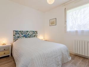 a white bedroom with a bed and a window at Apartment Le Domaine des roches by Interhome in Trouville-sur-Mer