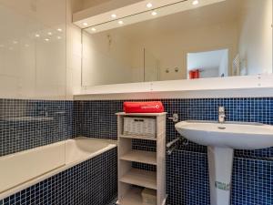 a bathroom with a sink and a tub and a mirror at Apartment Le Domaine des roches by Interhome in Trouville-sur-Mer