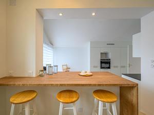 eine Küche mit einer Theke mit zwei Stühlen in der Unterkunft Holiday Home Le Ketch by Interhome in Saint-Philibert