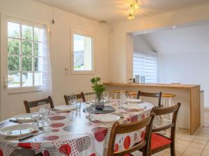 ein Esszimmer mit einem Tisch und Stühlen sowie eine Küche in der Unterkunft Holiday Home Le Ketch by Interhome in Saint-Philibert