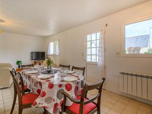 ein Esszimmer mit einem Tisch, Stühlen und einem Fenster in der Unterkunft Holiday Home Le Ketch by Interhome in Saint-Philibert