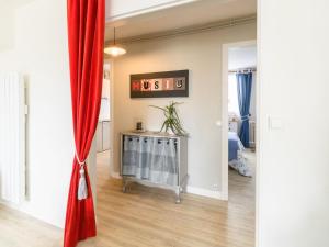 widok na salon z czerwoną zasłoną w obiekcie Apartment Dans la forêt de Pin by Interhome w mieście La Teste-de-Buch