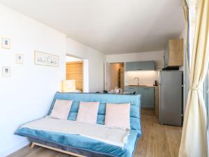 un soggiorno con un divano blu e una cucina di Apartment Port Arcachon-5 by Interhome ad Arcachon