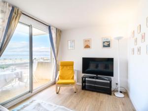 un soggiorno con TV e sedia gialla di Apartment Port Arcachon-5 by Interhome ad Arcachon