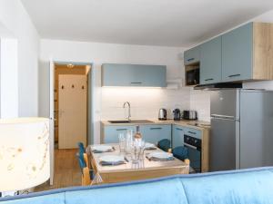 una cucina con un tavolo e un divano blu di Apartment Port Arcachon-5 by Interhome ad Arcachon Altre 21 foto