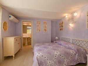 een paarse slaapkamer met een bed en een wastafel bij Apartment La Bastide de Claude by Interhome in La Roquette-sur-Siagne