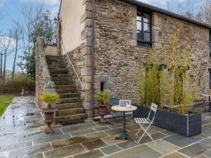 een terras met een tafel en stoelen en een bakstenen gebouw bij Holiday Home Les Grands Près by Interhome in Cancale