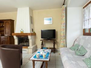 een woonkamer met een bank en een tv bij Holiday Home Glaïeuls by Interhome in Saint-Méloir-des-Ondes