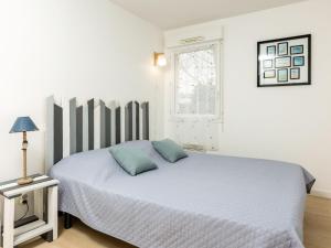 Un dormitorio con una cama con almohadas azules. en Apartment Les Caps Horniers by Interhome, en Pleurtuit
