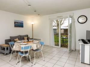salon ze stołem, krzesłami i kanapą w obiekcie Apartment Les Caps Horniers by Interhome w mieście Pleurtuit