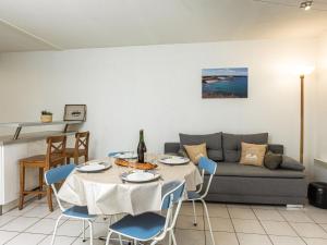 a living room with a table and a couch at Apartment Les Caps Horniers by Interhome in Pleurtuit