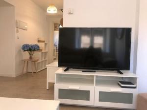 - une télévision à écran plat installée sur un centre de divertissement blanc dans l'établissement Cómodo, independiente y coqueto apartamento, à Santander