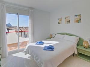 Biała sypialnia z łóżkiem i balkonem w obiekcie Holiday Home Imperial Park-8 by Interhome w mieście Calpe