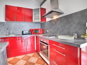 a kitchen with red cabinets and a red microwave at Holiday Home Les Oyats by Interhome in Dolus d'Oléron