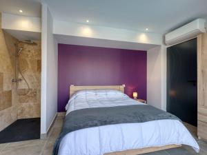 ein lila Schlafzimmer mit einem Bett und einer Dusche in der Unterkunft Villa Villa des écureuils by Interhome in Lanton