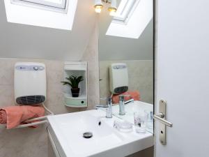 a bathroom with a sink and a mirror at Holiday Home Coquelicot by Interhome in Saint-Méloir-des-Ondes