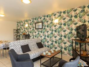 uma sala de estar com um sofá e uma televisão em Holiday Home Coquelicot by Interhome em Saint-Méloir-des-Ondes