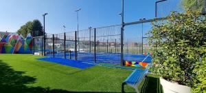 un parc avec un banc bleu devant une clôture dans l'établissement POST A POST, à Alba