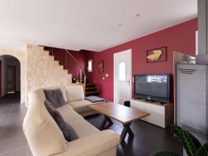 Una sala de estar con un sofá blanco y un televisor. en Holiday Home Lesgau by Interhome, en Saint-Martin-de-Seignanx