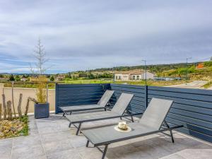 a row of chairs and a table on a patio at Holiday Home Villa Hestia by Interhome in Goudargues