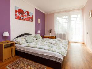 ein Schlafzimmer mit einem großen Bett mit lila Wänden in der Unterkunft Apartment Lien by Interhome in Balatonlelle