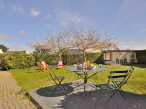 stół i dwa krzesła na dziedzińcu w obiekcie Holiday Home Ker Vignan by Interhome w mieście Pleumeur-Bodou