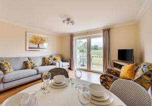 a living room with a couch and a table with wine glasses at Sailors Rest in Wangford