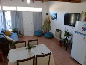 ein Wohnzimmer mit einem Tisch und einem Kühlschrank in der Unterkunft Cacique Catriel "EN PLANTA BAJA" in Catriel