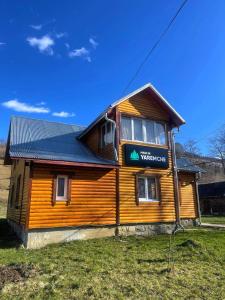 a wooden building with a sign in front of it at Made in Yaremche in Yaremche