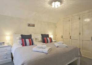 1 dormitorio con 1 cama grande y toallas. en Sandcastle Cottage, en Southwold