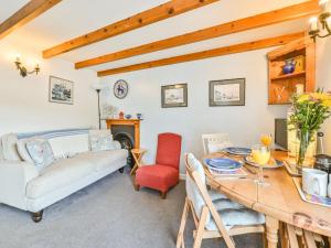 a living room with a table and a couch at Holiday Home Dolphin Cottage by Interhome in Mevagissey