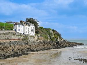 a group of white houses on a hill next to the ocean at Holiday Home Dolphin Cottage by Interhome in Mevagissey