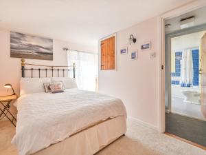 a bedroom with a large bed and a bathroom at Holiday Home Dolphin Cottage by Interhome in Mevagissey