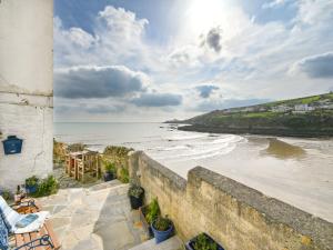 a view of the ocean from a stone wall at Holiday Home Dolphin Cottage by Interhome in Mevagissey