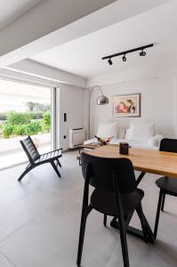 a living room with a table and chairs and a bed at Athens-Riviera luxury apartment sea view Voula in Athens