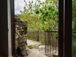a door leading to a porch with a stone wall at Lavandeira Douro Nature & Wellness in Baião +106 photos