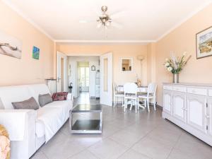 a living room with a white couch and a table at Apartment La plage du Cap by Interhome in Roquebrune-Cap-Martin