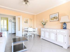 a living room with a white cabinet and a table at Apartment La plage du Cap by Interhome in Roquebrune-Cap-Martin +15 photos