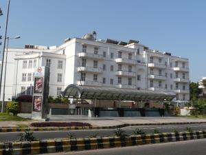 een groot wit gebouw met een bushalte voor de deur bij Ambassador, New Delhi - IHCL SeleQtions in New Delhi