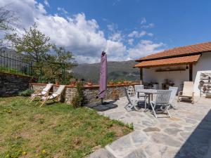 un patio con sedie e un tavolo con un ombrellone di Villa Anna by Interhome a Ville San Pietro