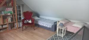 una piccola camera con letto e sedia di Les Grands Bois a La Flèche