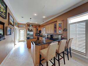 a kitchen with a large island with chairs in it at A Mid-Summer's Night Dream in Destin