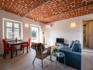a living room with a blue couch and a brick wall at Apartment La Rosa by Interhome in Costigliole dʼAsti +25 photos